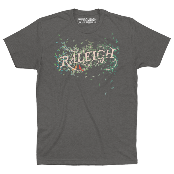 Heavy metal colored t-shirt, spells RALEIGH across the chest in white, surrounded by leaves. Two small red birds sit under the word Raleigh.